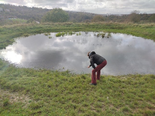 Person examining a pond